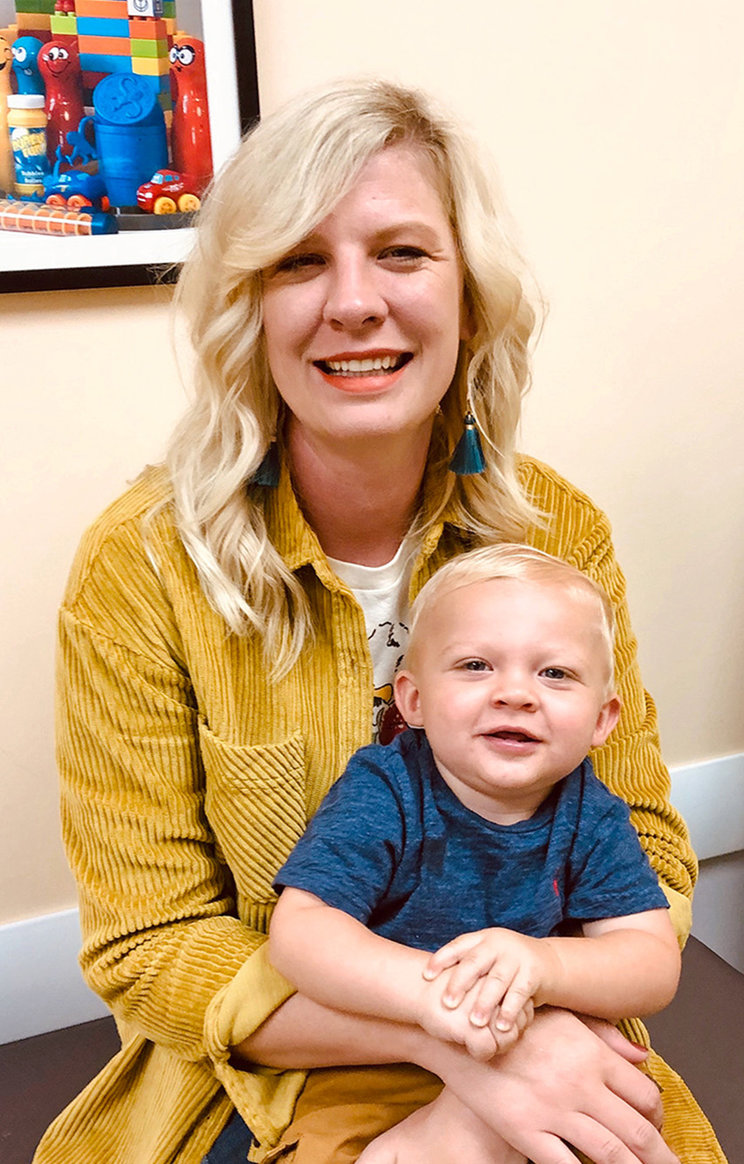 Brady, an infant with SMA, sitting on his mother Nicole's lap